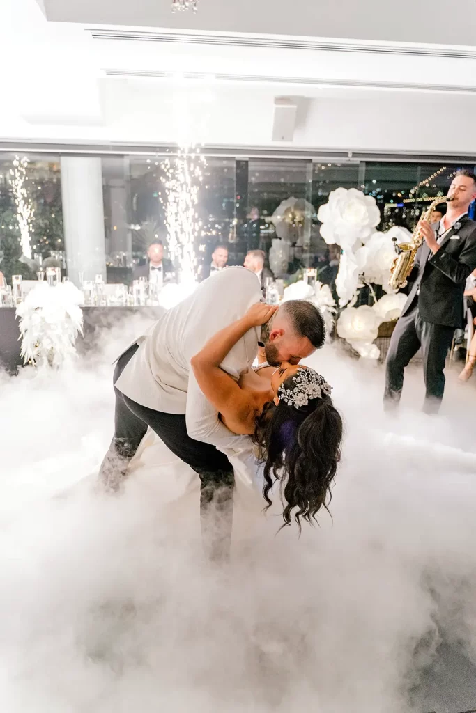 Brisbane wedding bride and groom kissing during the first dance with cold sparklers and smoke machines going on around them.